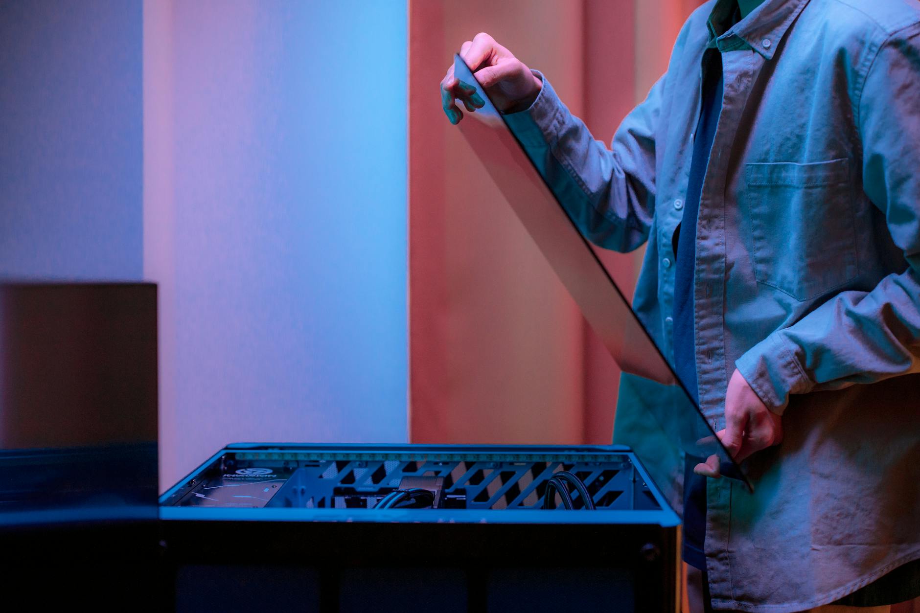 Mężczyzna montuje szklaną obudowę i porządkuje kable w komputerze gamingowym