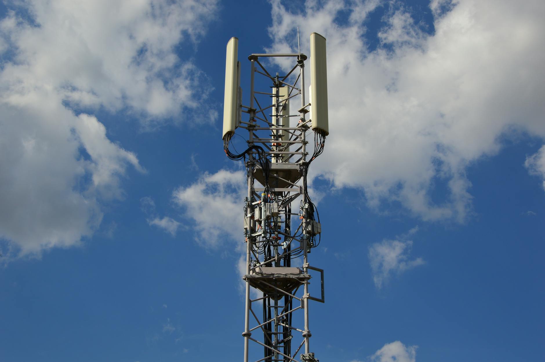 Maszt sieci komórkowej 5G na tle intensywnie błękitnego nieba Maszt sieci komórkowej 5G na tle intensywnie błękitnego nieba