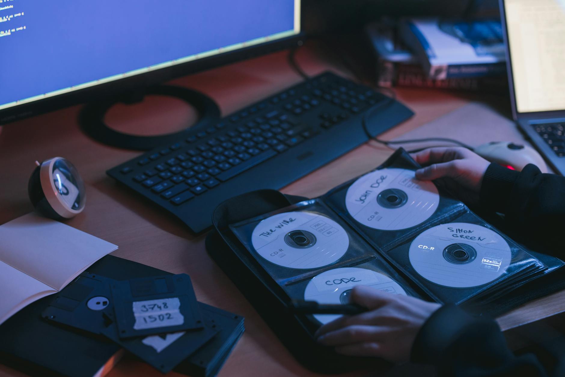 Dłonie przy płytach CD na biurku w technicznym środowisku pracy