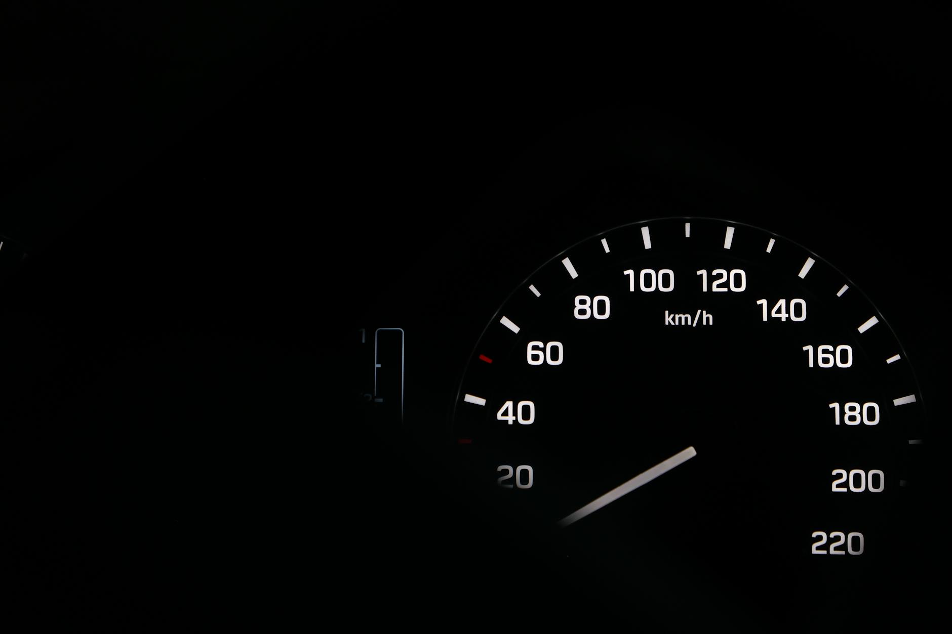 Nocne zbliżenie na podświetlony prędkościomierz samochodu
