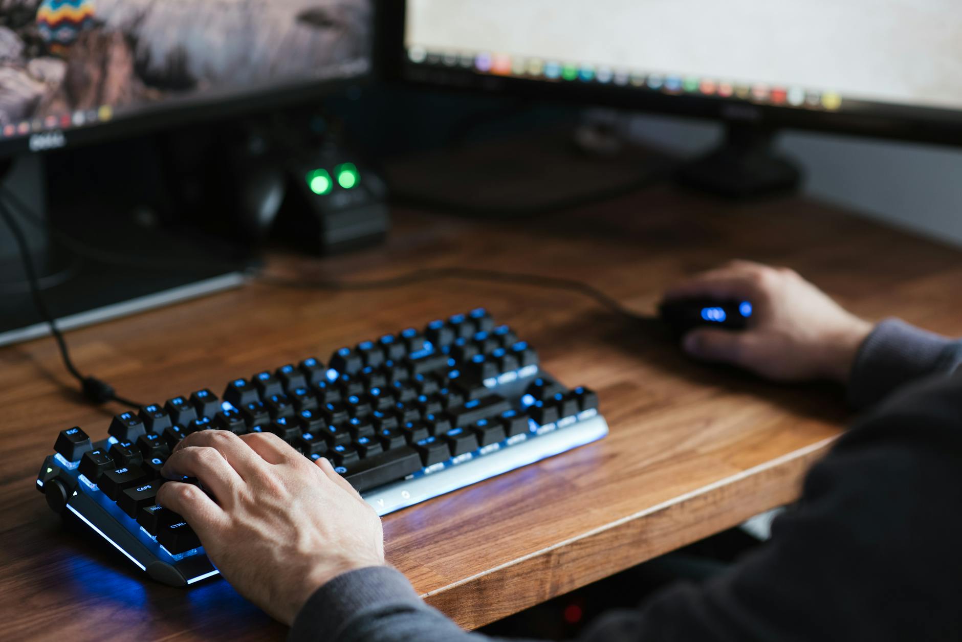 Programista przy biurku korzysta z myszy i podświetlanej klawiatury
