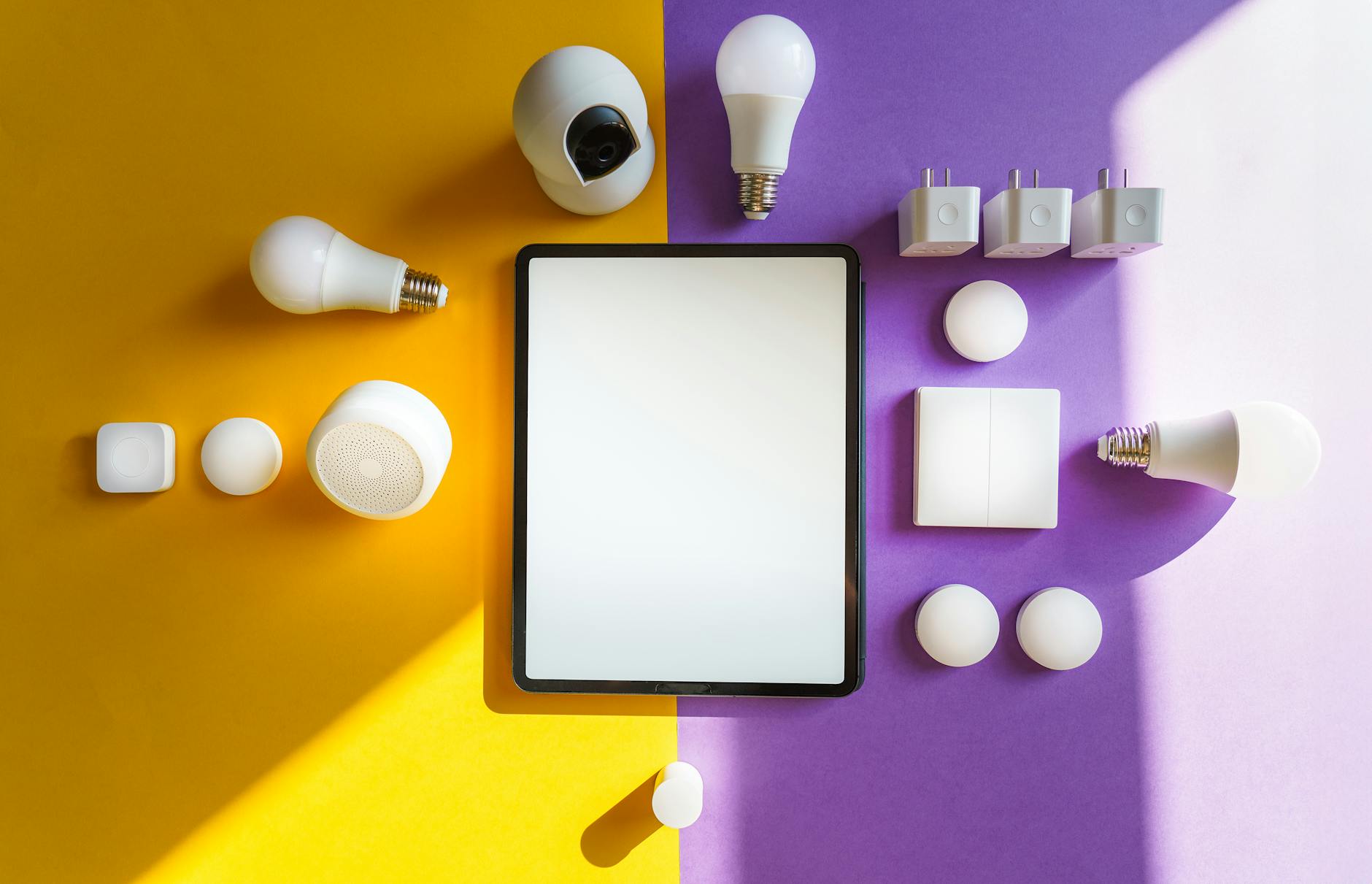 Urządzenia smart home i tablet na dwukolorowym tle z góry