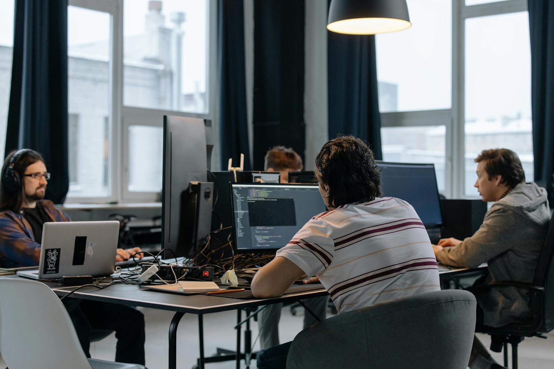 Zespół programistów pracuje nad kodem w nowoczesnym biurze tech