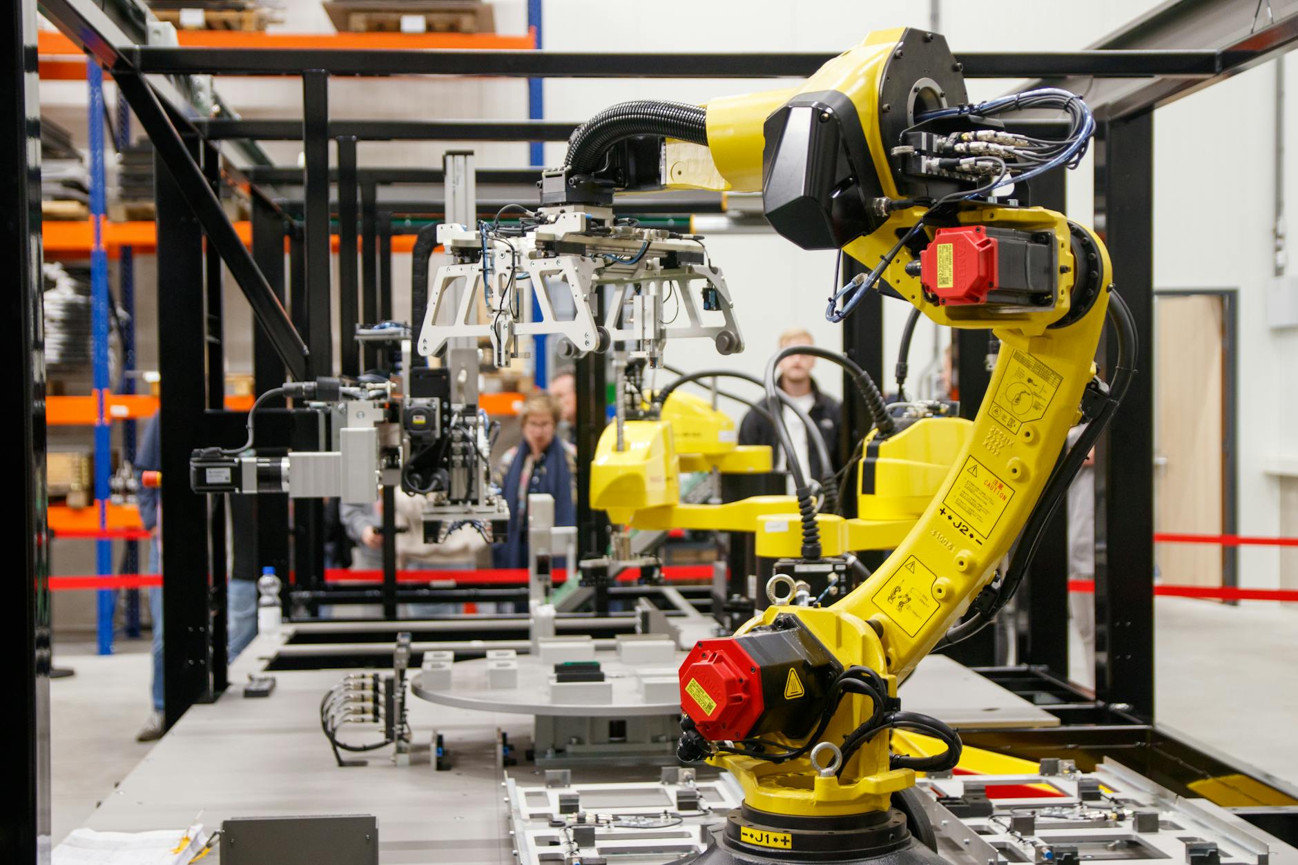 Żółte ramię robota przemysłowego pracujące w nowoczesnej hali produkcyjnej