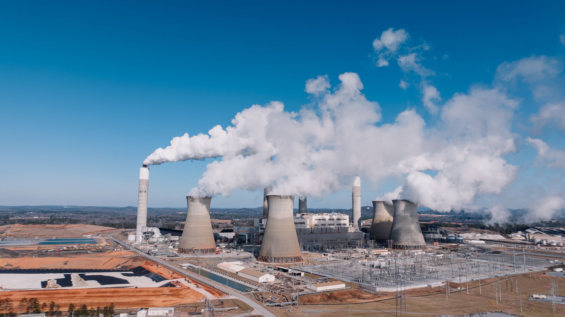 Elektrownia węglowa z kominami dymiącymi widziana z lotu ptaka