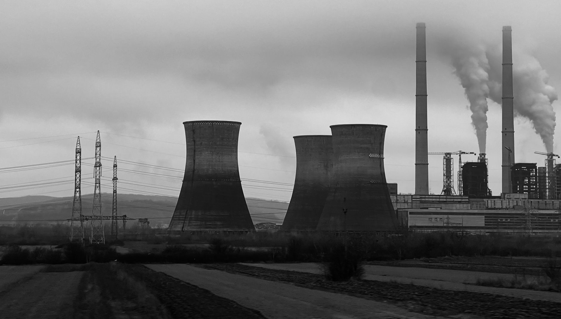 Elektrownia z kominami i chłodniami kominowymi w czarno-białym kadrze
