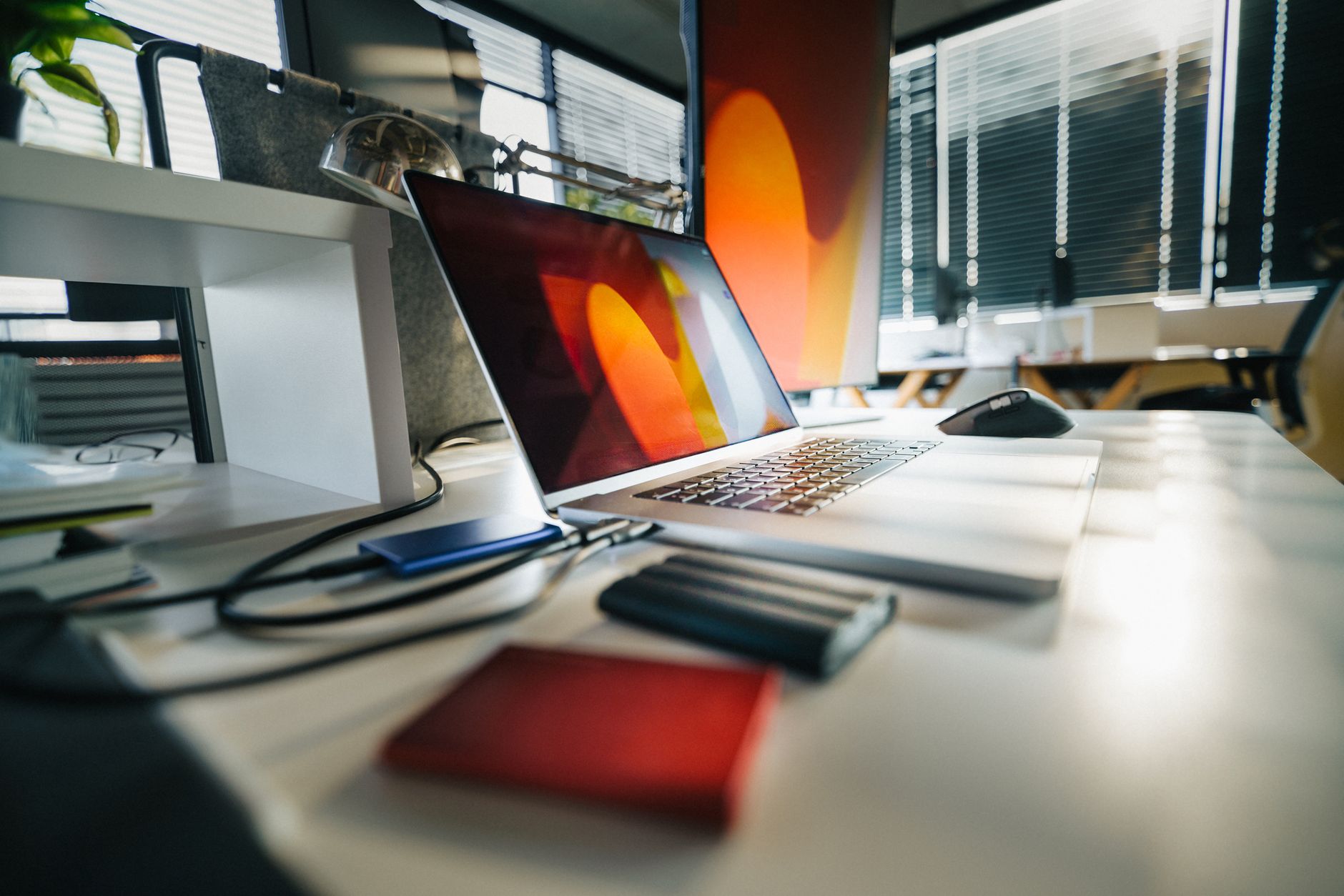 Laptop na biurku obok zewnętrznych dysków w nowoczesnym biurze