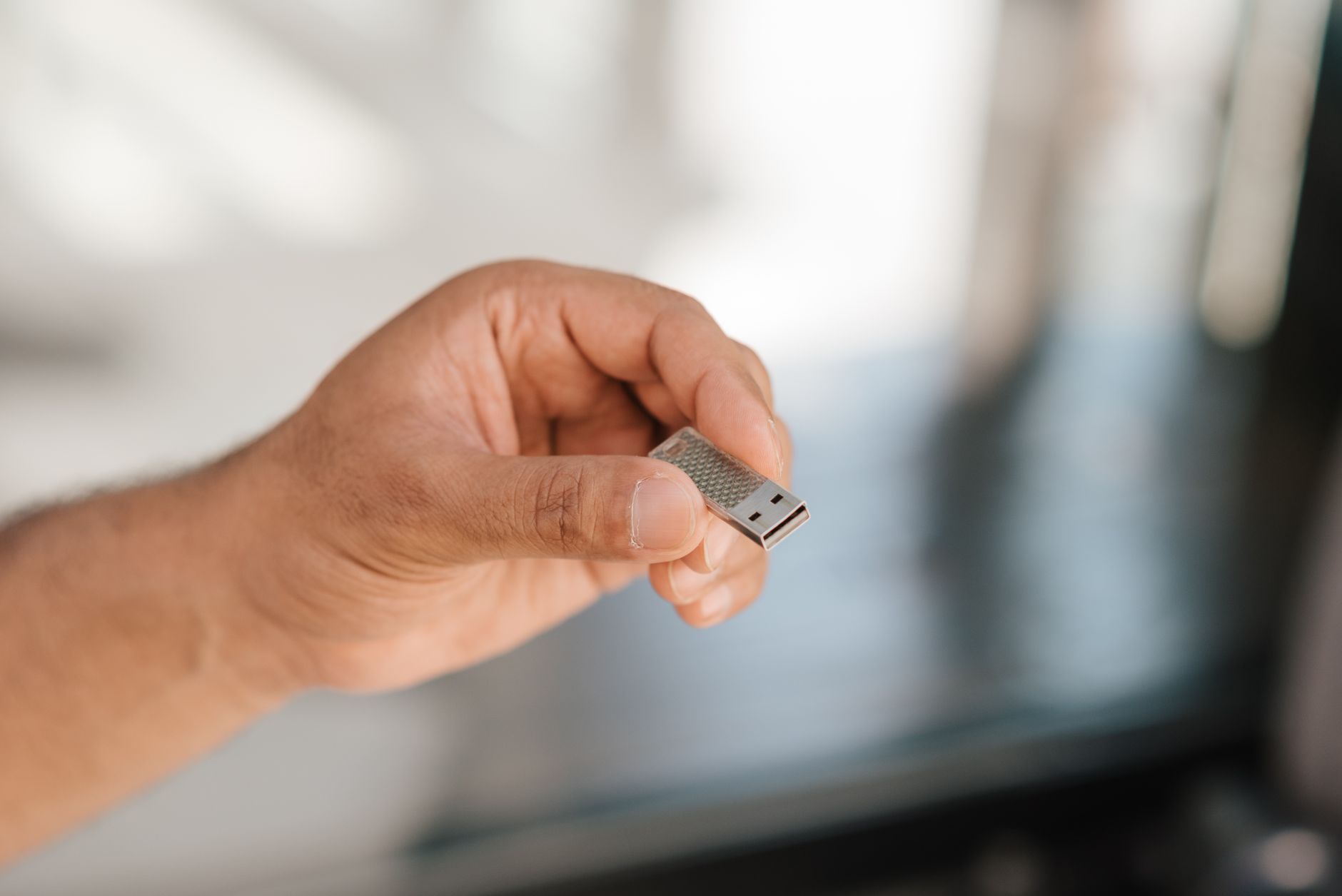 Mężczyzna trzyma pendrive do bezpiecznego przechowywania danych