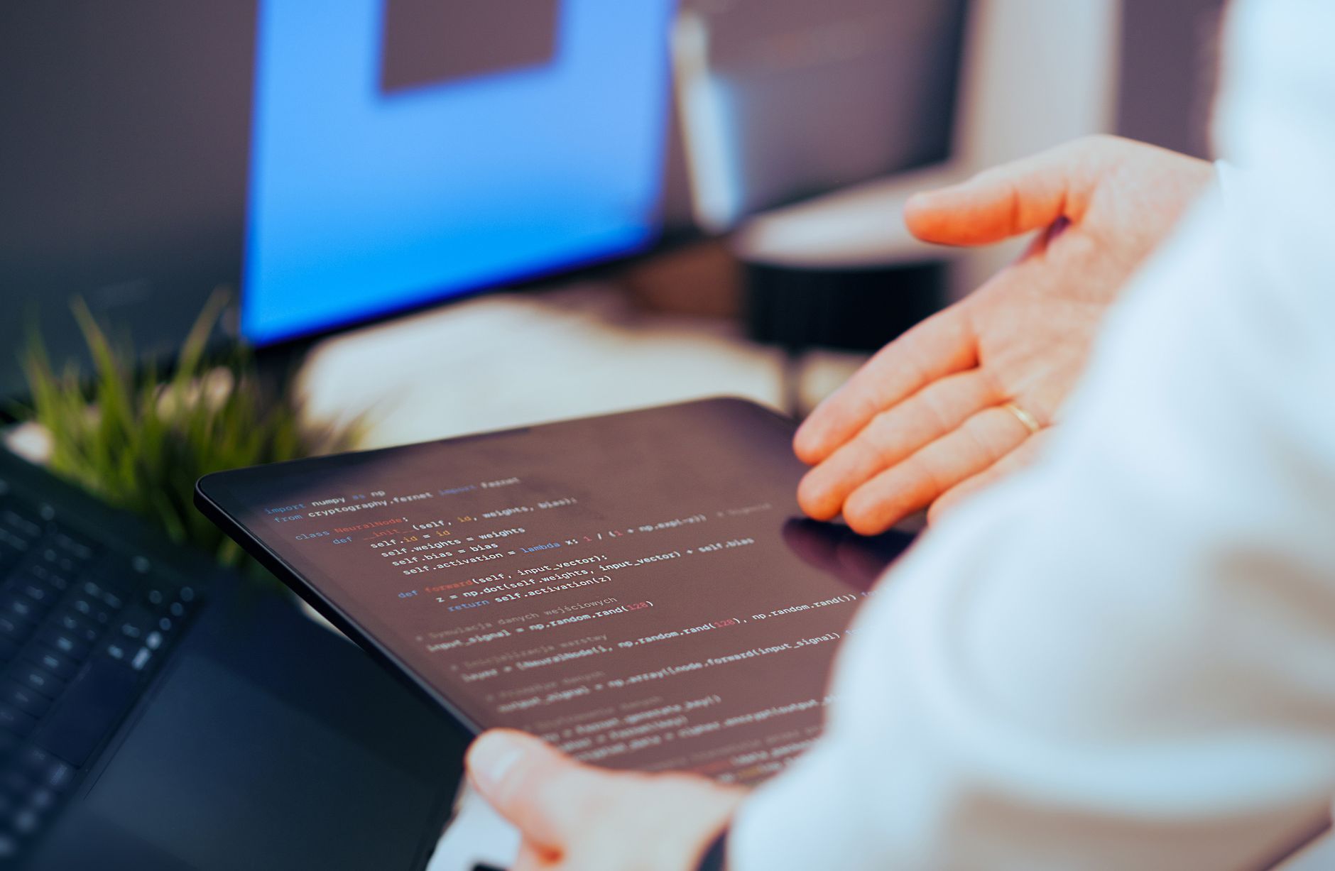 Programista analizuje kod na tablecie w nowoczesnym biurze Programista analizuje kod na tablecie w nowoczesnym biurze